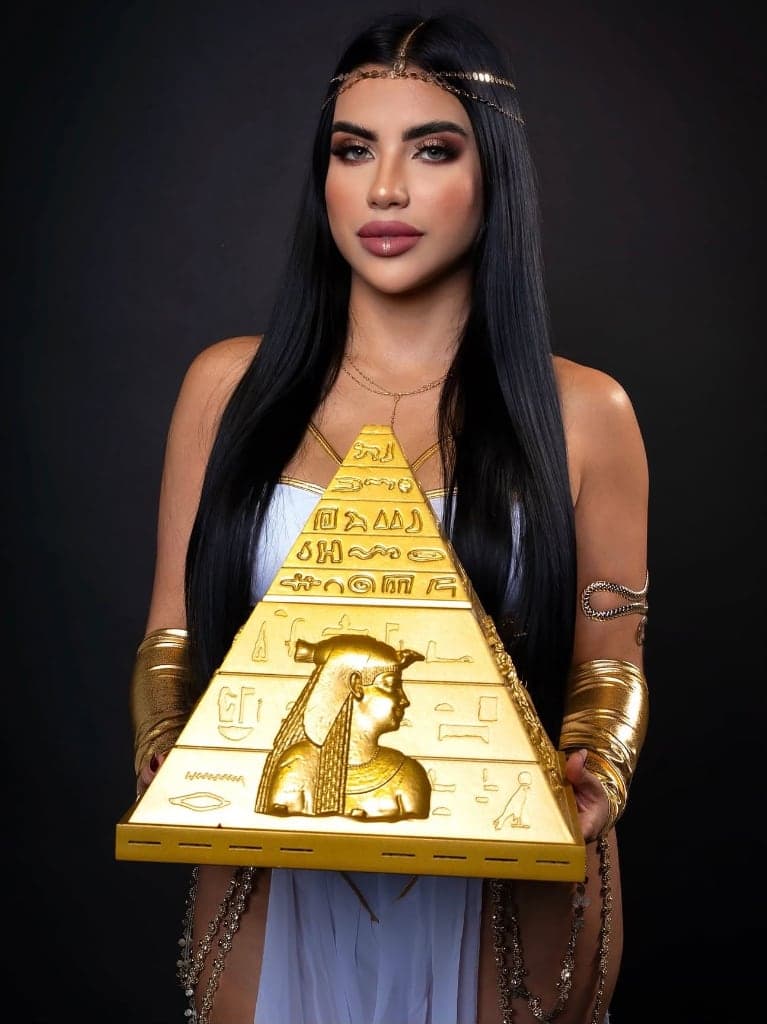Cleopatra Hookah royal hostess attired in Egyptian regalia presenting the Luxury Pyramid Edition hookah